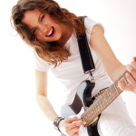 Portrait of beautiful young and attractive womanplaying her guitar at home